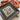 Cross-stitched piece with a turkey and 'Thankful' text, framed in a rustic wooden box, on a neutral background.