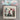 Cross-stitched decorative item with a woman, cat, and building design, tied with ribbons.