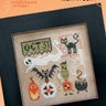 Halloween-themed cross-stitch pattern with decorative elements on a black frame.
