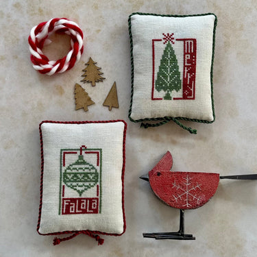 Decorative Christmas-themed pillows and a bird ornament on a marble surface