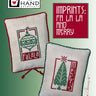 Two embroidered Christmas-themed pillows with 'Heart in Hand' branding on a green background.