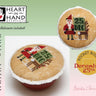 Two cross-stitched round ornaments with Santa Claus designs on a light green background, featuring 'Heart in Hand' branding.
