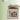 Cross-stitched design of a cabin with a barn quilt and sheep on a box, featuring the Heart in Hand Needleart logo.